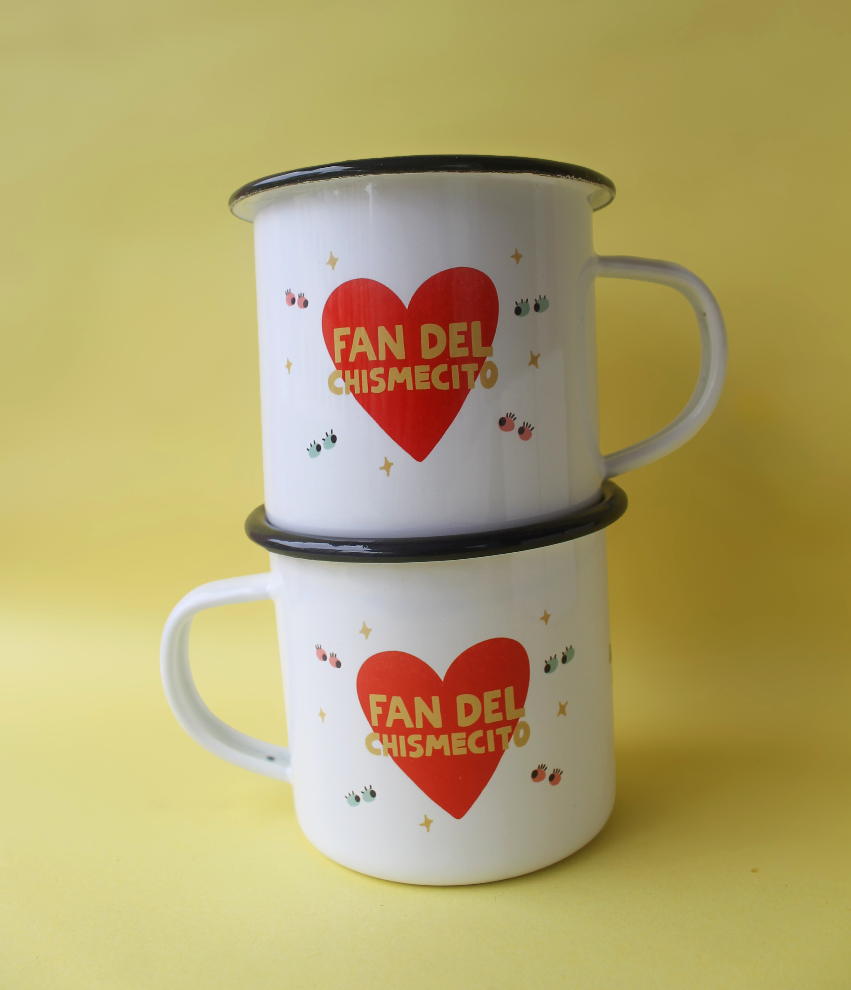 foto de dos tazas de metal enlozado, una sobre otra, ambas tienen impresa la frase Fan del chismecito dentro de un corazón rojo.